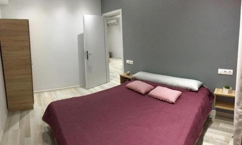 a bedroom with a purple bed with two pink pillows at RHODIAN TREASURE Spiridione apartment in Rhodes Town