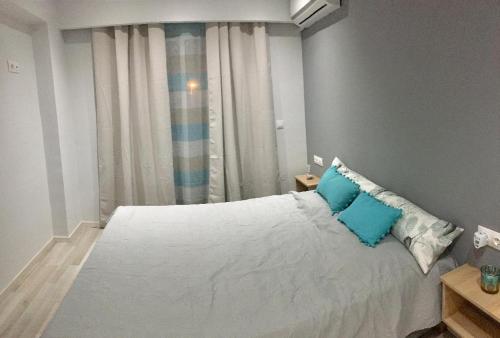a bedroom with a large white bed with blue pillows at RHODIAN TREASURE Spiridione apartment in Rhodes Town