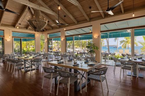 a restaurant with tables and chairs and the ocean at Elysian Beach Resort in St Thomas