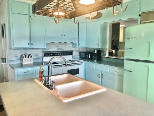 a kitchen with a sink and a white refrigerator at Lake Front Home Near Peek'n Peak in Findley Lake