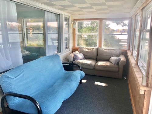 a living room with a couch and a couch and windows at Lake Front Home Near Peek'n Peak in Findley Lake