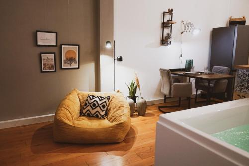 a living room with a chair and a table at Stilvolles City-Loft mit privatem Whirlpool in Trier