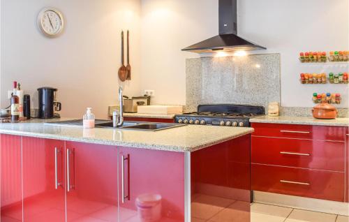 - une cuisine avec des placards rouges et une cuisinière dans l'établissement 3 Bedroom Gorgeous Home In Gondrin, à Gondrin