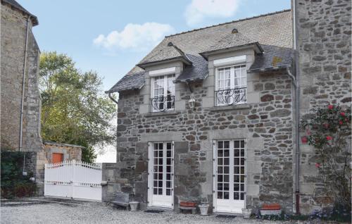 an old stone house with white windows and a white fence at Cozy Home In Plancoët With Wifi in Plancoët