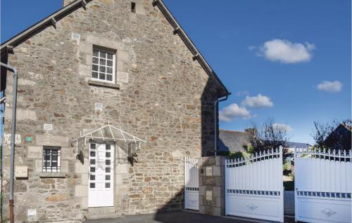 an old stone building with a white fence at Cozy Home In Plancoët With Wifi in Plancoët
