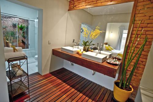 a bathroom with two sinks and a mirror at Pousada e Restaurante Caminhos do Bom Café in Jacutinga