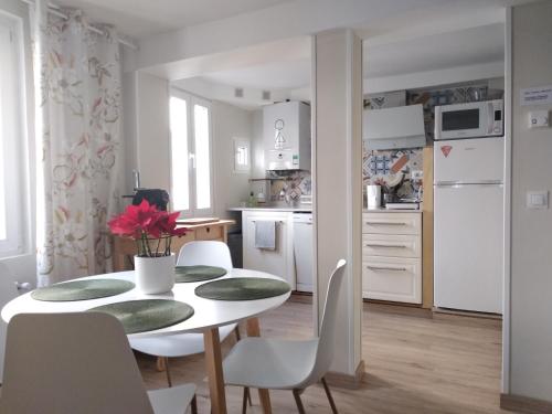 Una cocina y un comedor con mesa y sillas. en Precioso apartamento en el centro de Santander, en Santander
