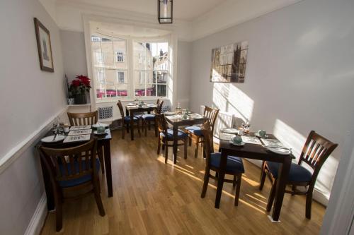 a dining room with tables and chairs and a window at Cathedral Gate in Canterbury