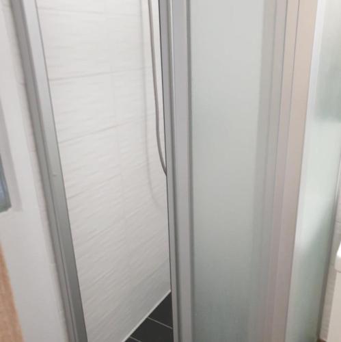 a glass door of a shower in a bathroom at Magyartenger Apartman Balatonlelle in Balatonlelle