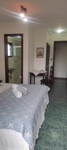 a bedroom with a bed and a table and chairs at Hotel Pousada Laje de Itauna in Saquarema