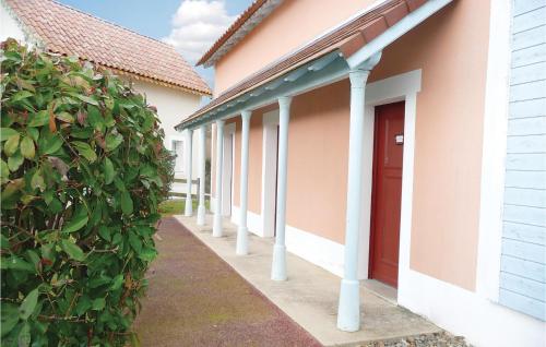 une rangée de maisons avec une porte rouge et une haie dans l'établissement 1 Bedroom Cozy Home In Marciac, à Marciac
