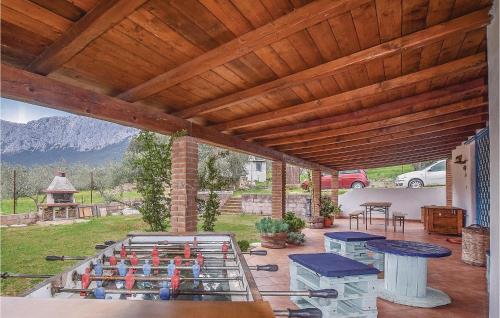 a patio with tables and benches and a wooden ceiling at Villa Antonietta in Oliena