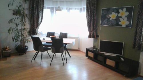 a dining room with a table and chairs and a television at Appartement July in Innsbruck