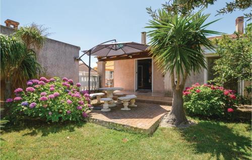 ボルゴにあるAwesome Home In Borgoのピクニックテーブルとヤシの木のあるパティオ