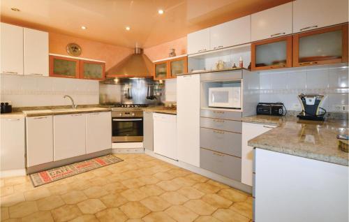 - une grande cuisine avec des armoires et des appareils blancs dans l'établissement Awesome Home In Borgo, à Borgo