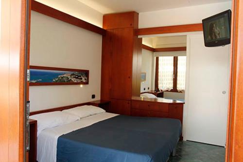a bedroom with a bed and a bathroom with a sink at Hotel Residence La Darsena in Agropoli