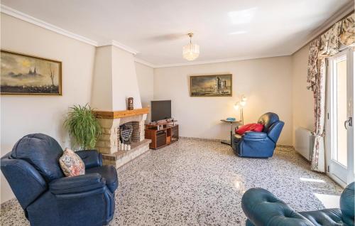 a living room with two blue chairs and a fireplace at Beautiful Home In Torremanzanas With Wifi in Torremanzanas