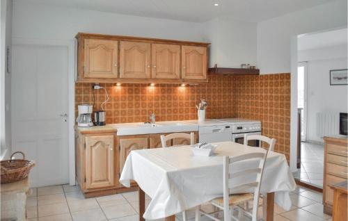 - une cuisine avec des placards en bois, une table et un évier dans l'établissement 3 Bedroom Lovely Home In Penvenan, à Penvénan