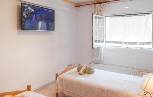 1 dormitorio con 1 cama y TV en la pared en 2 Bedroom Amazing Apartment In Tossa De Mar en Tossa de Mar