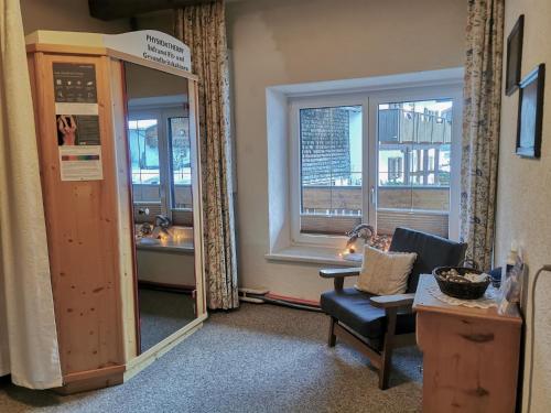 a room with a mirror and a chair and a window at Gästehaus Sonne in Bichlbach