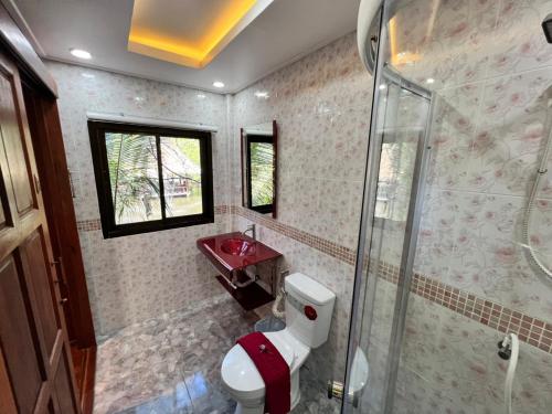 a bathroom with a shower and a toilet and a sink at บ้านสวนในฝัน-ตลาดน้ำท่าคา in Samut Songkhram