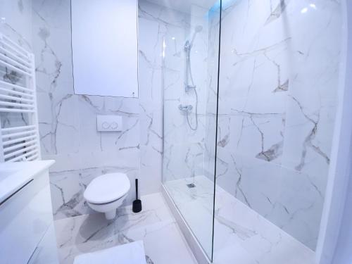 biała łazienka z toaletą i prysznicem w obiekcie Home in Paris - Paris East w Paryżu