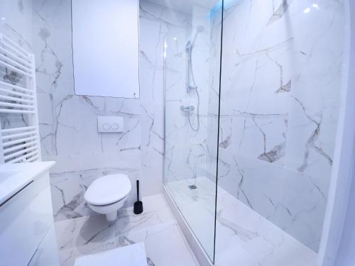 une salle de bain blanche avec toilettes et douche dans l'établissement Home in Paris - Paris East, à Paris