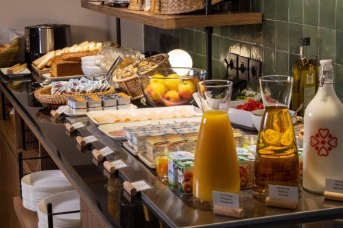 ein Buffet mit Speisen und Getränken auf der Theke in der Unterkunft Hotel de l'Aqueduc in Paris