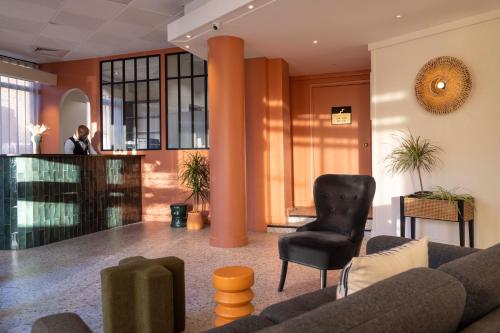 a man standing at a podium in a lobby at Hotel de l'Aqueduc in Paris