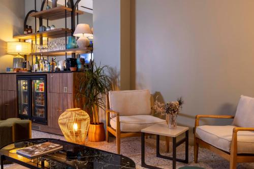 a living room with two chairs and a table at Hotel de l'Aqueduc in Paris
