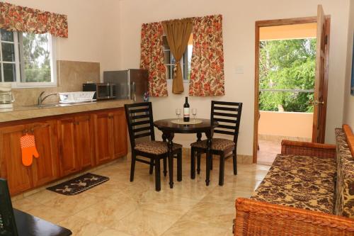 cocina y comedor con mesa y sillas en Stoney Gate Cottages, en Negril