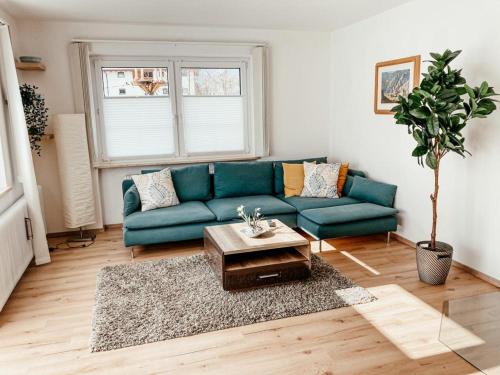 a living room with a blue couch and a table at Ferienwohnung Olympia Axams in Innsbruck