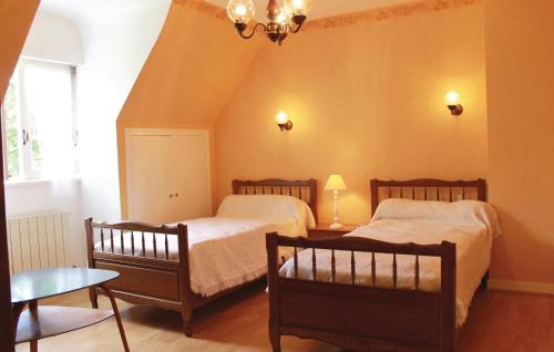 1 dormitorio con 2 camas y mesa en Cozy Home In Ploneour-lanvern With Kitchen, en Plonéour-Lanvern