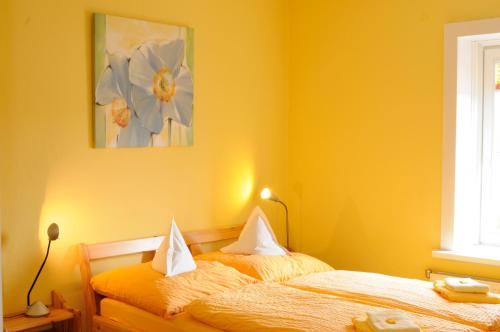 a bedroom with two beds with yellow walls at Hotel zur alten Stadtmauer in Lübeck