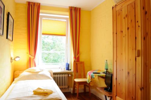 Schlafzimmer mit einem Bett und einem Fenster in der Unterkunft Hotel zur alten Stadtmauer in Lübeck