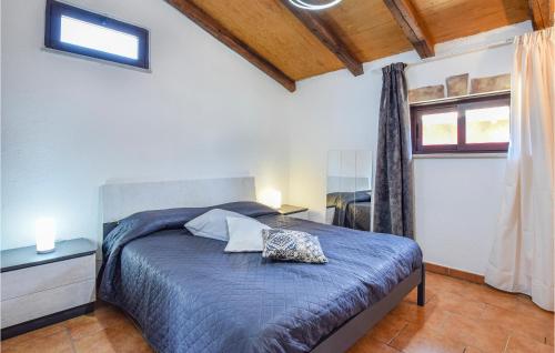 a bedroom with a blue bed and a window at Nice Home In Torranova With Kitchen in Torrenova
