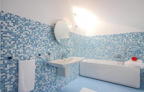 y baño de azulejos azules con lavabo y bañera. en Villateresa, en Montecorice