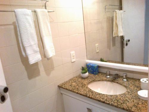un baño con lavabo y espejo en Apartamento em Ondina, en Salvador