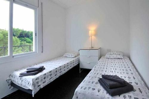 two twin beds in a room with a window at Apartamento con increíbles vistas y terraza in Girona
