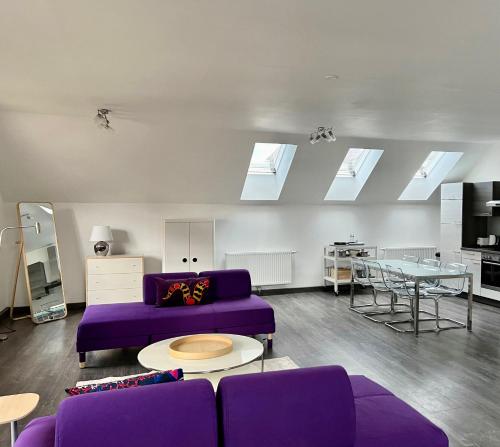 a living room with a purple couch and a table at Loft am Hauptplatz in Gloggnitz