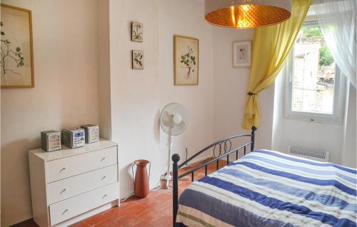 ein Schlafzimmer mit einem Bett, einer Kommode und einem Fenster in der Unterkunft 2 Bedroom Nice Home In Saint-gervais-sur-mare in Saint-Gervais-sur-Mare