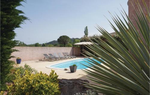 une piscine avec des chaises longues et un parasol dans l'établissement Gorgeous Home In Cessenon Sur Orb, à Cessenon