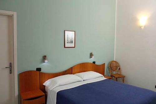 a bedroom with a blue bed and a chair at Hotel Residence La Darsena in Agropoli