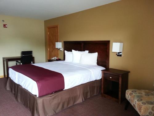 una habitación de hotel con una cama grande con sábanas blancas en Americas Best Value Inn Bryant, en Bryant