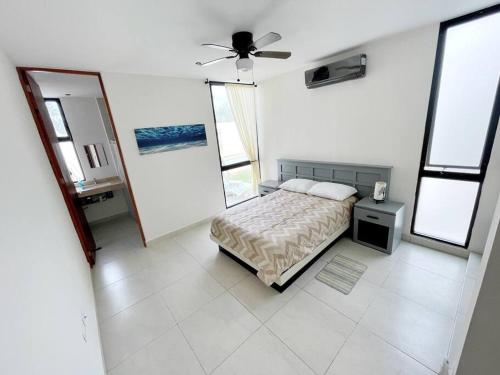 a bedroom with a bed and a ceiling fan at Casa Otavia, con alberca para 6 huéspedes y mascotas in Conkal