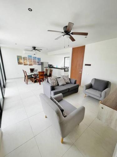 a living room with a couch and a chair at Casa Otavia, con alberca para 6 huéspedes y mascotas in Conkal