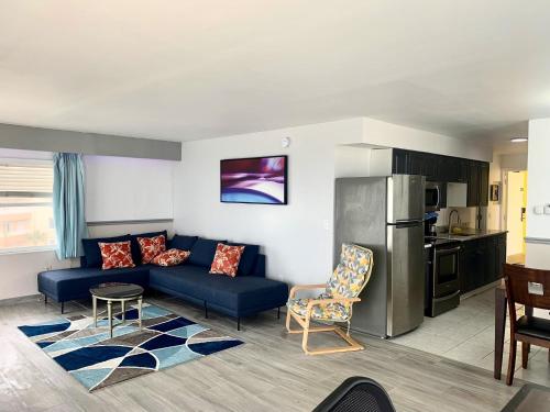 a living room with a blue couch and a kitchen at Sand Castle Motel in Daytona Beach Shores