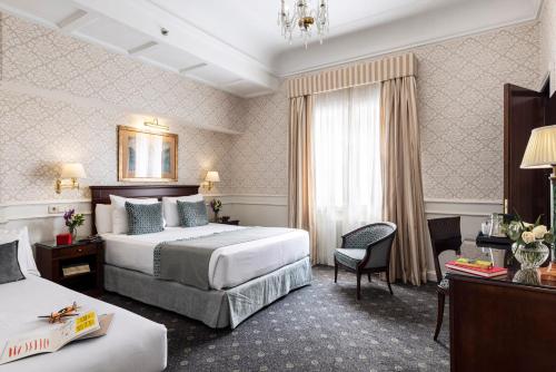 una camera d'albergo con due letti e una finestra di Emperador a Madrid