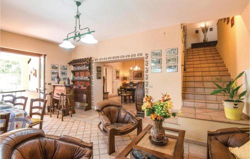 a living room with leather chairs and a staircase at Quadrifoglio in Configni