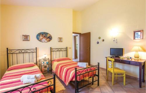 two beds in a room with a desk and a computer at Quadrifoglio in Configni